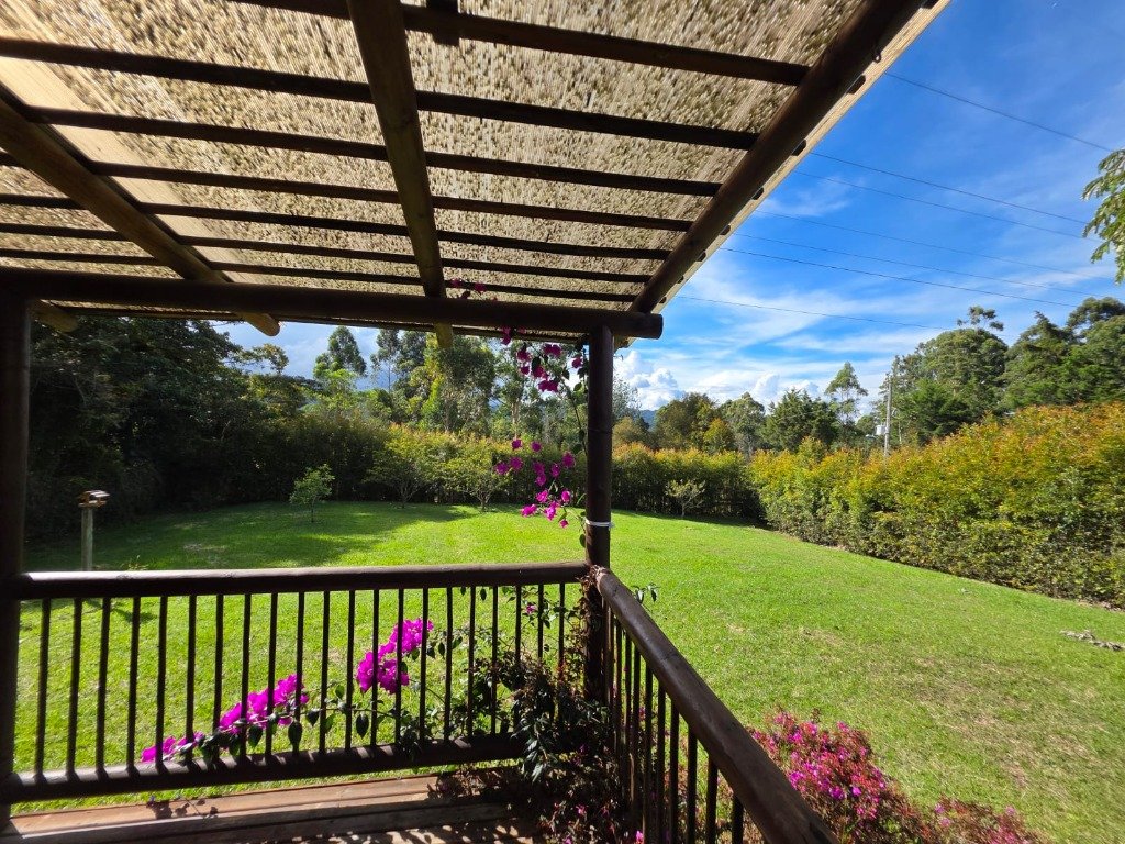 Panorámica de los prados verdes privados de 1.500 m² y jardines floridos desde la terraza de Casa Campestre La Isabela en Las Lomitas